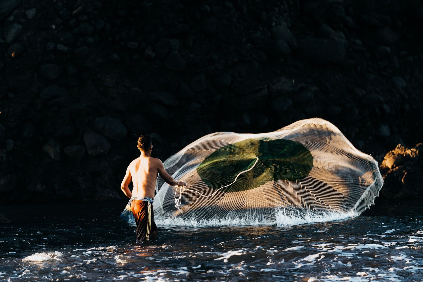 Fisherman casting a net at El Tunco Beach